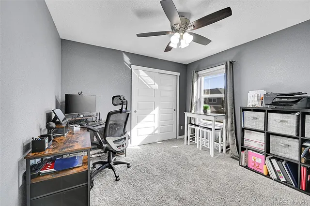a view of a workspace with furniture and a window