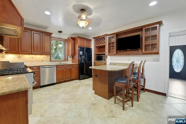 a kitchen with kitchen island granite countertop wooden cabinets and stainless steel appliances
