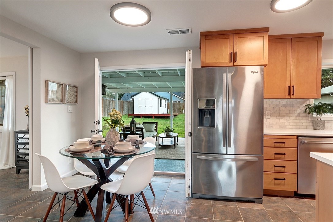 3708 Northeast 22nd Street Renton, WA 98056 - Photo 6 of 20 a kitchen with a refrigerator a stove a dining table and chairs