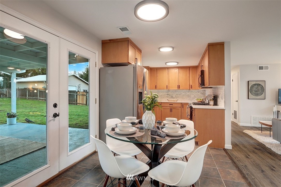 3708 Northeast 22nd Street Renton, WA 98056 - Photo 8 of 20 a kitchen with a table chairs refrigerator and microwave