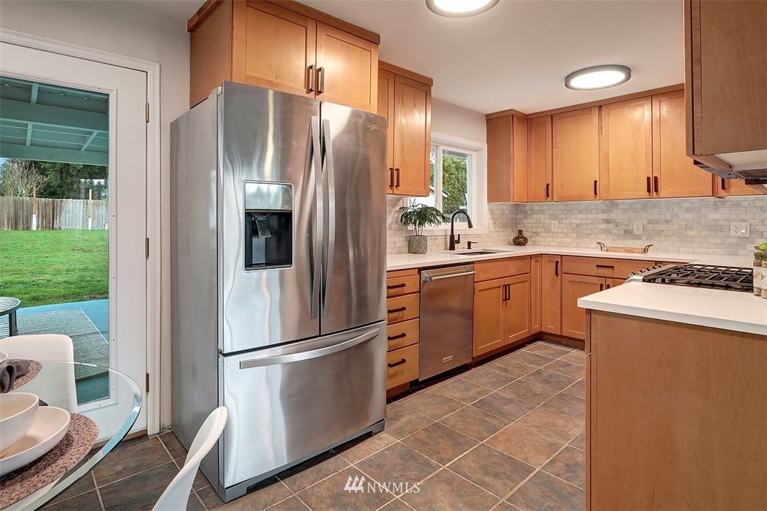3708 Northeast 22nd Street Renton, WA 98056 - Photo 10 of 20 a kitchen with stainless steel appliances a refrigerator sink and cabinets