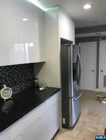 a kitchen with a refrigerator and a stove top oven