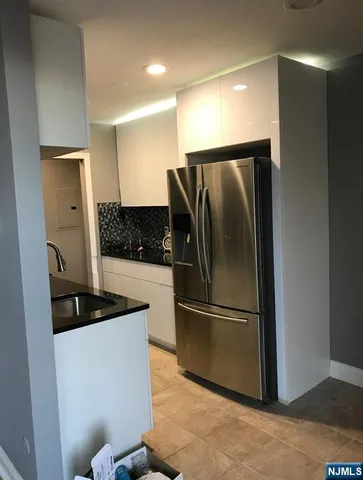a metallic refrigerator freezer sitting in a kitchen