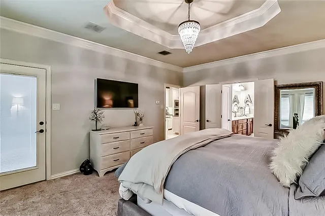 a spacious bedroom with a bed and a flat screen tv