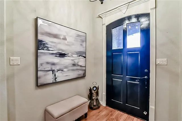 a hallway with painting on the wall and a mirror
