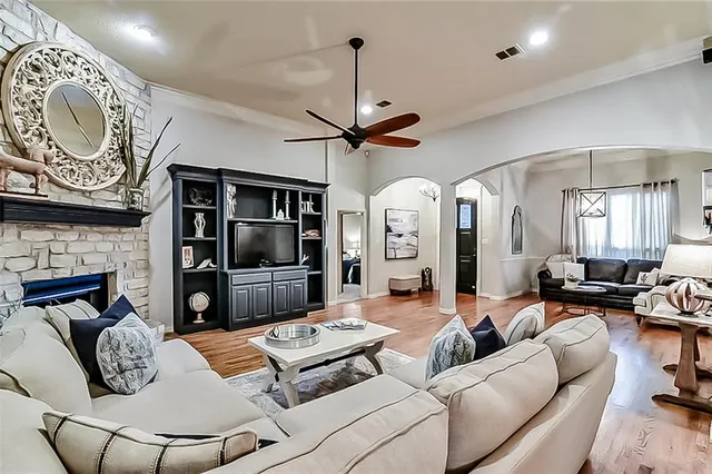 a living room with furniture a clock and a flat screen tv