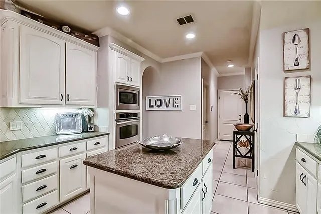 a kitchen with granite countertop a sink a stove and cabinets