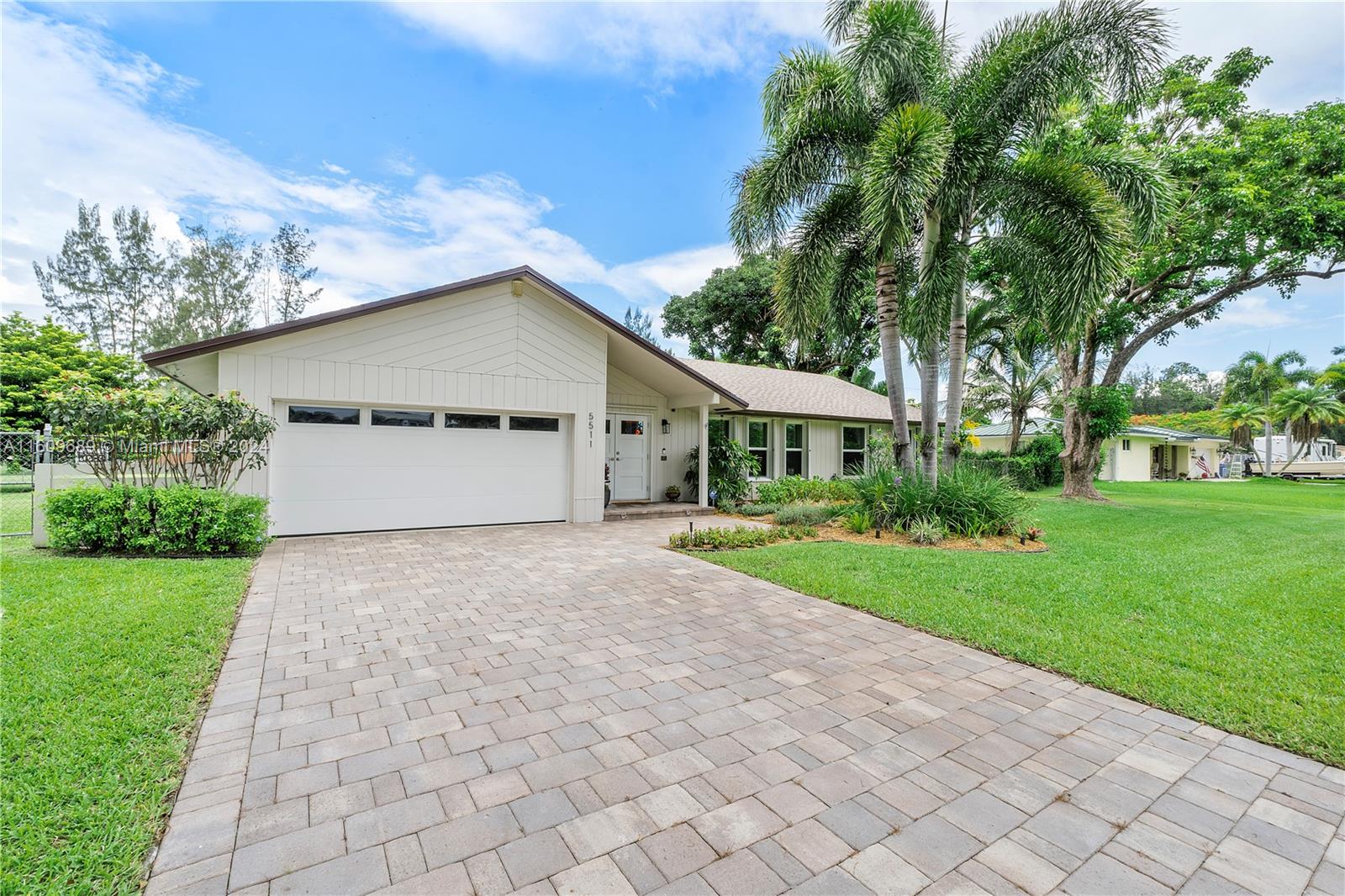 5511 Southwest 196th Lane Southwest Ranches, FL 33332 - Photo 90 of 94 a front view of a house with a yard and garage