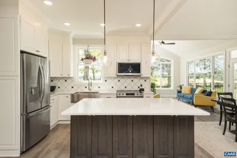 a kitchen with stainless steel appliances granite countertop a refrigerator sink and white cabinets