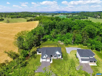 an aerial view of a house with a garden and lake view