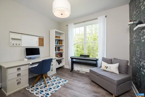 a view of a livingroom with wooden floor and furniture