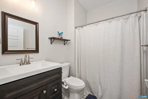 a bathroom with a sink a toilet and mirror