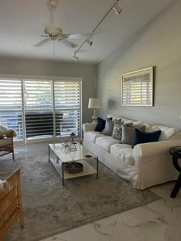 a living room with furniture and floor to ceiling windows