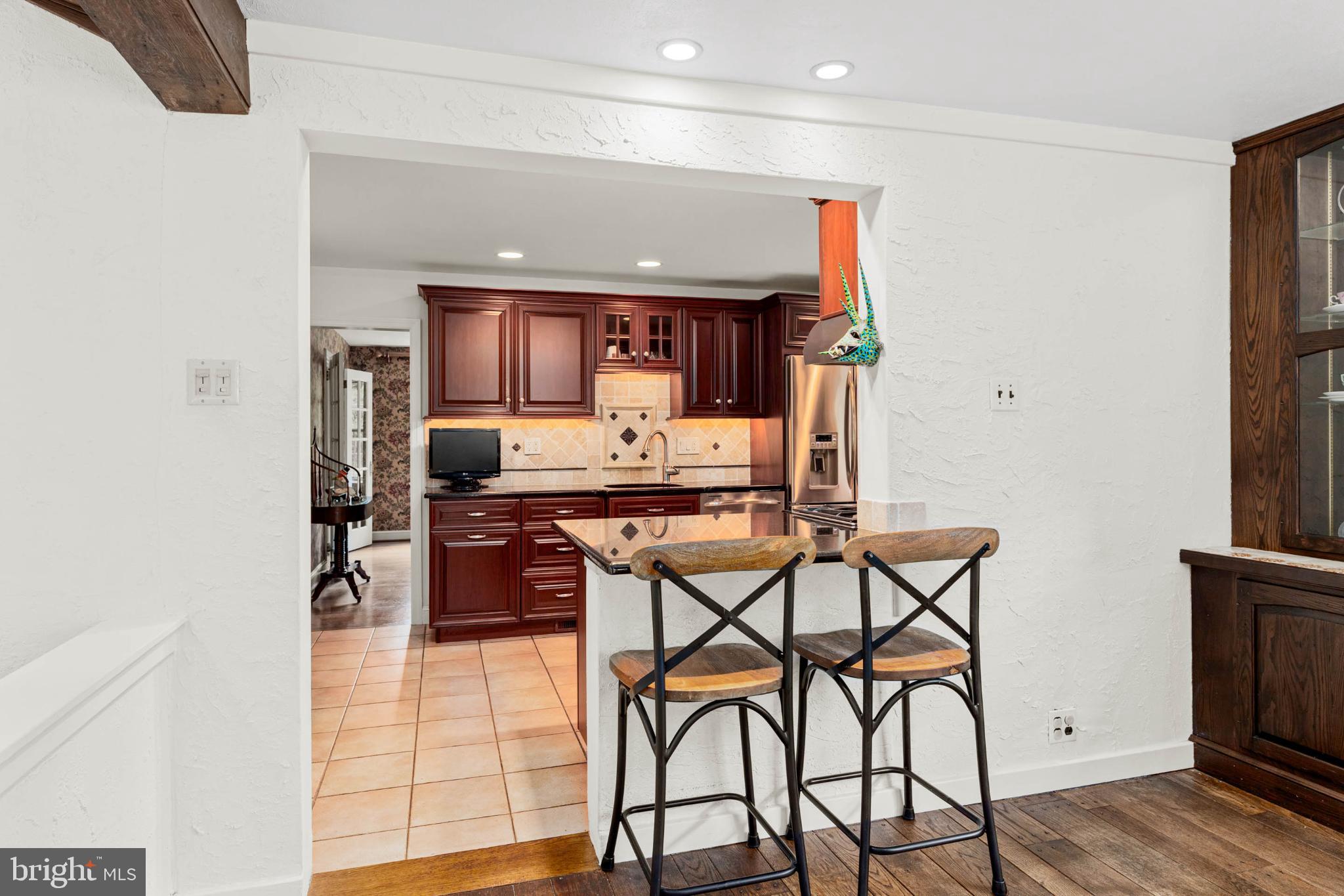 407 Fairview Road Penn Valley, PA 19072 - Photo 17 of 59 Kitchen with counter seating & rich wood accents.