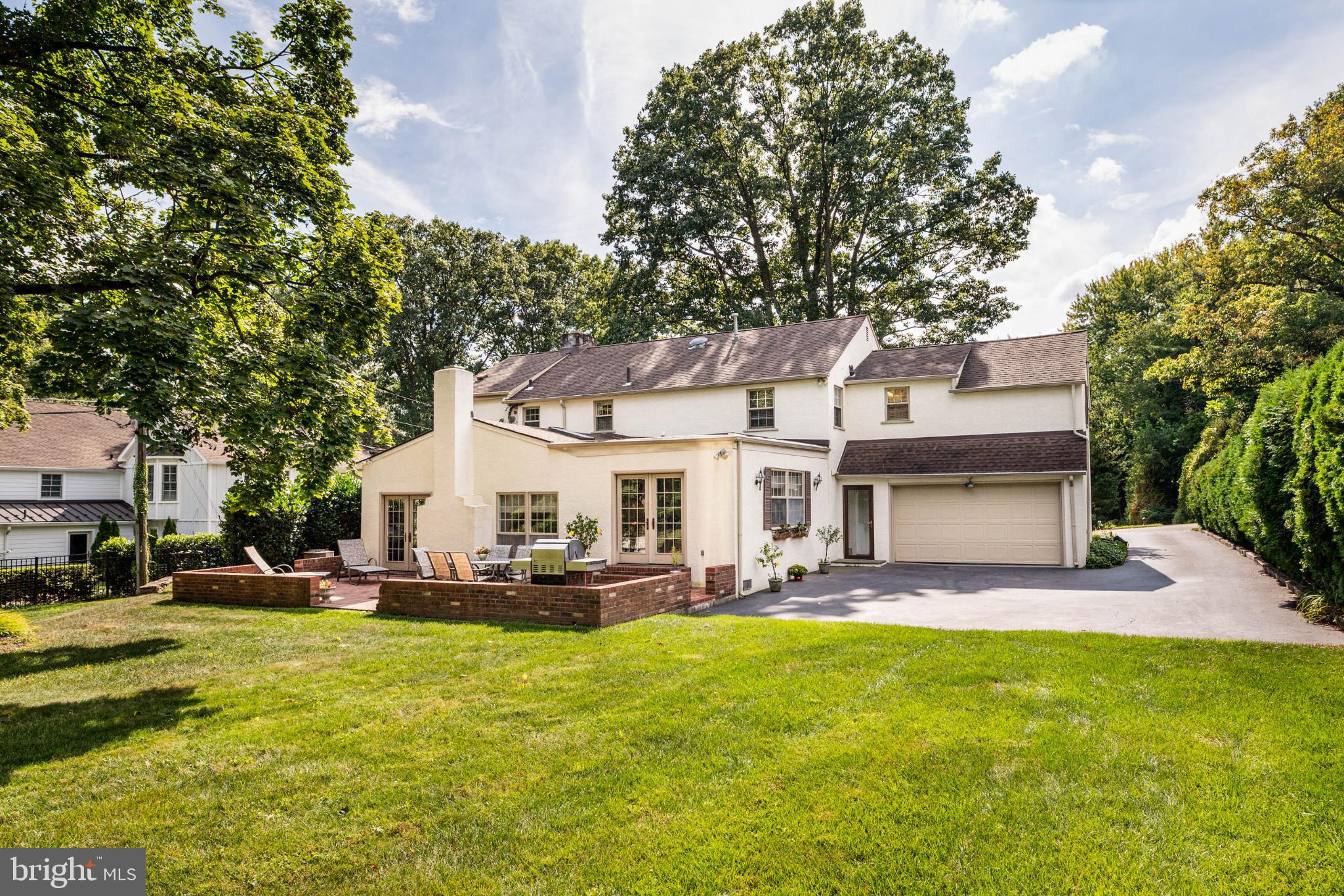 407 Fairview Road Penn Valley, PA 19072 - Photo 52 of 59 Back of property w/ brick patio and 2-car garage.