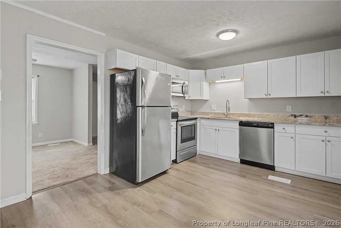 1931 Pumpkin Road Fayetteville, NC 28304 - Photo 15 of 48 a kitchen with a refrigerator sink and cabinets