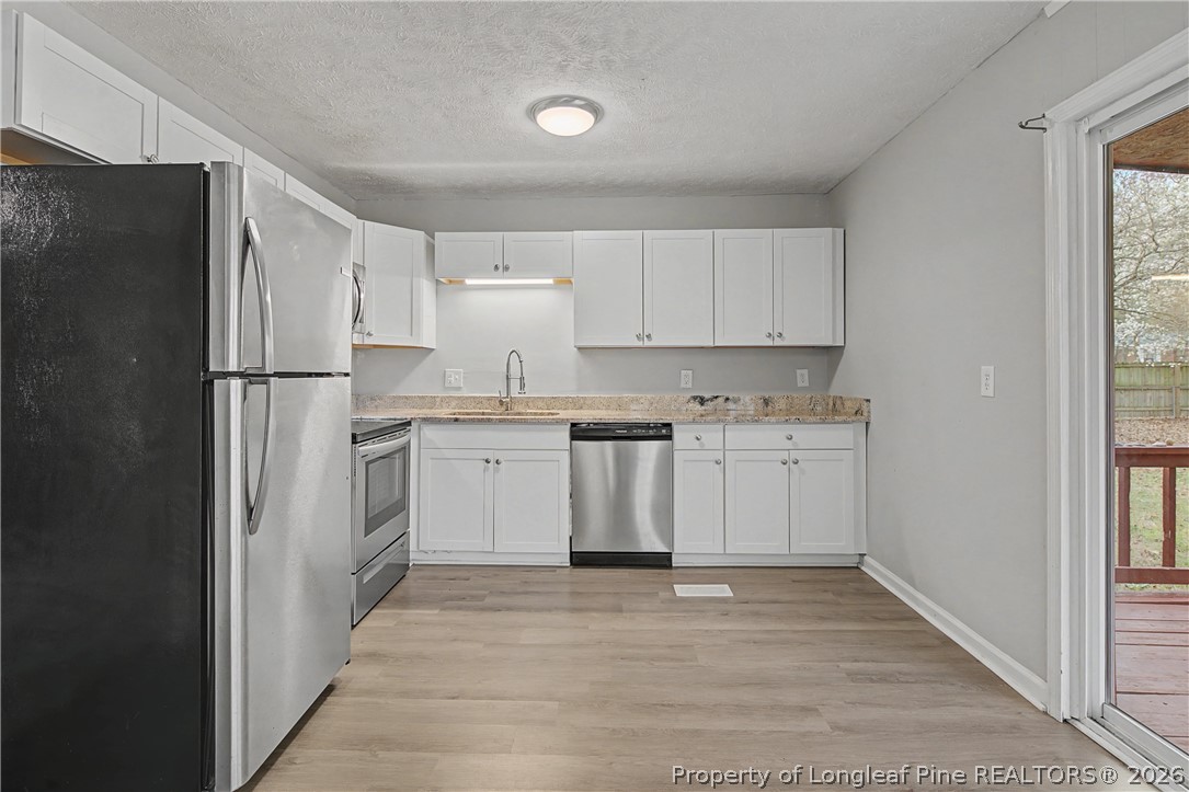 1931 Pumpkin Road Fayetteville, NC 28304 - Photo 16 of 48 a kitchen with white cabinets and white appliances