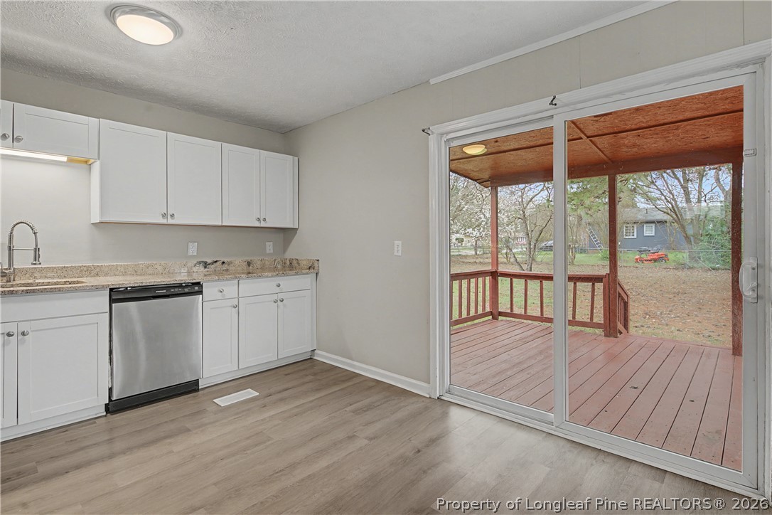 1931 Pumpkin Road Fayetteville, NC 28304 - Photo 17 of 48 a kitchen with wooden floors and white cabinets