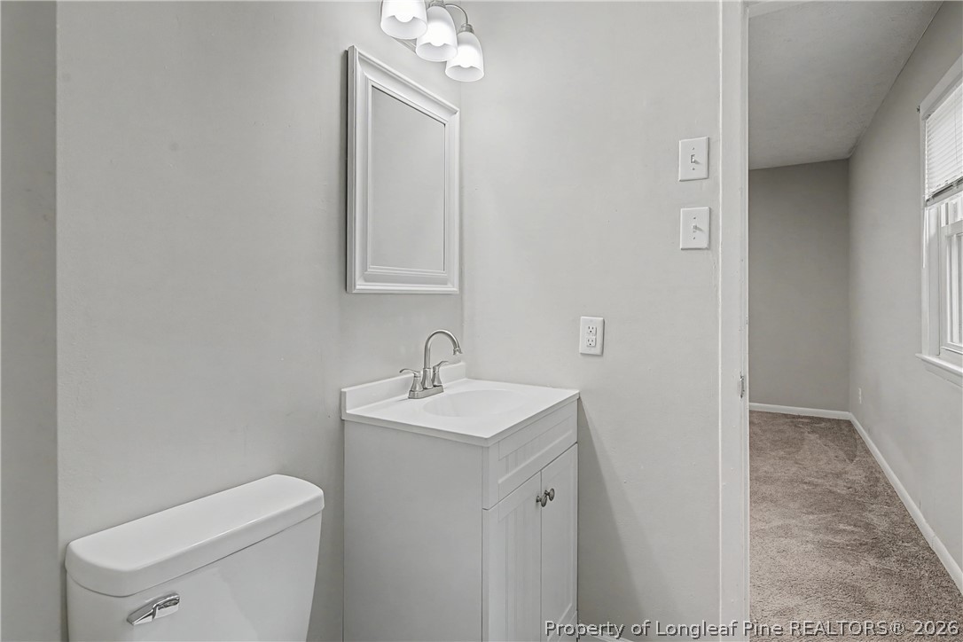 1931 Pumpkin Road Fayetteville, NC 28304 - Photo 30 of 48 a bathroom with a toilet a sink and mirror