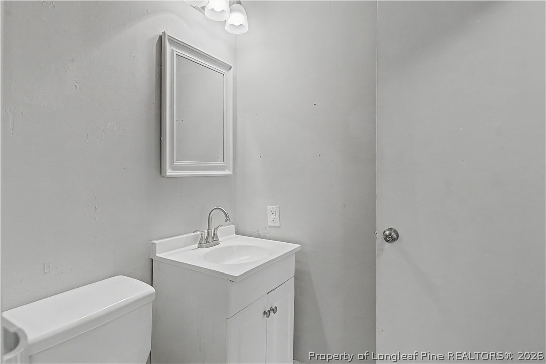 1931 Pumpkin Road Fayetteville, NC 28304 - Photo 36 of 48 a bathroom with a toilet sink and mirror