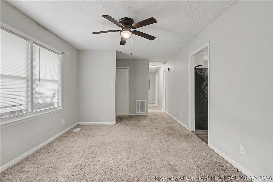 1931 Pumpkin Road Fayetteville, NC 28304 - Photo 9 of 48 an empty room with ceiling fan and windows