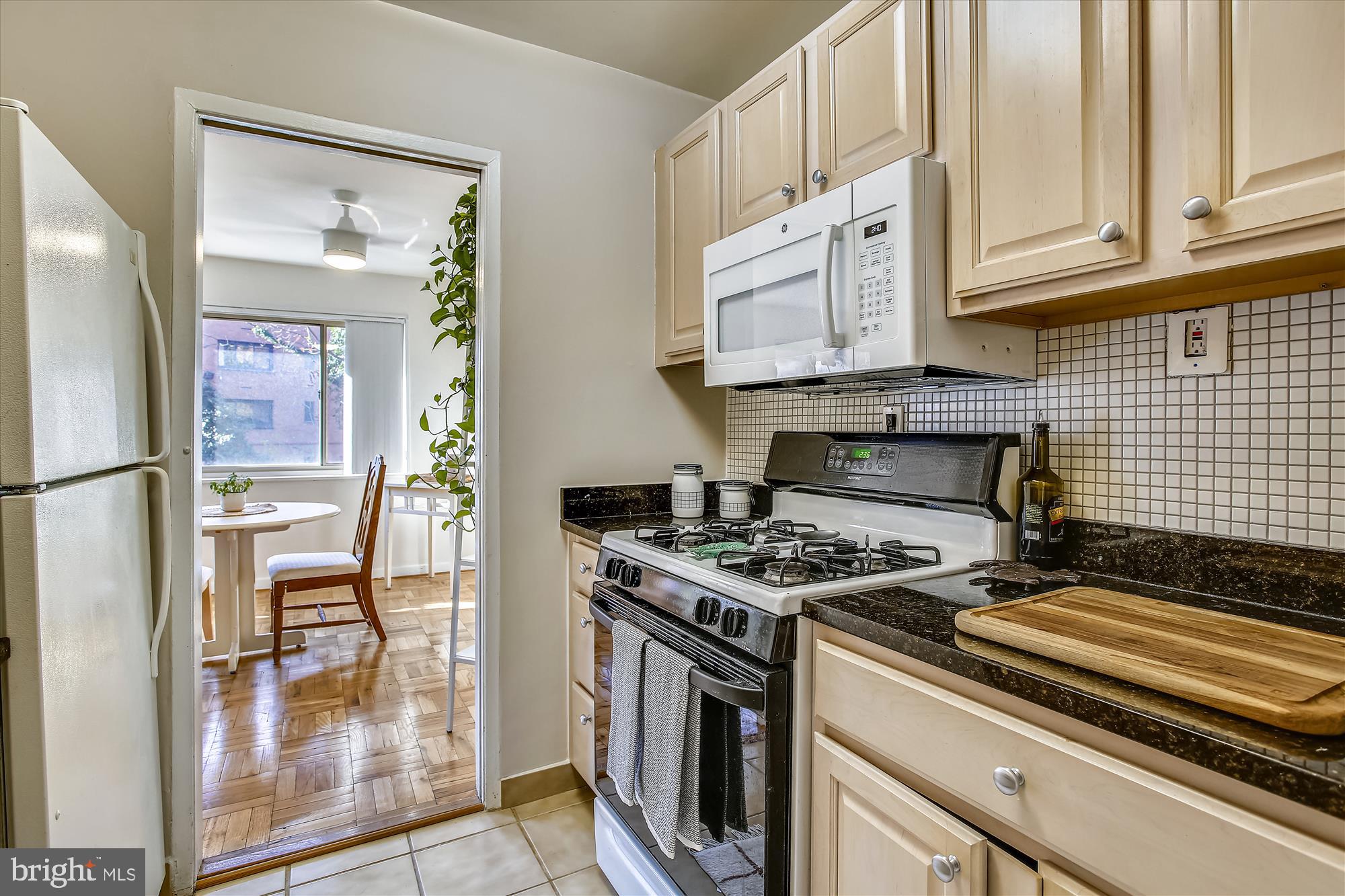 3900 Tunlaw Road Northwest, Unit 118 Washington, DC 20007 - Photo 12 of 58 a kitchen with stainless steel appliances granite countertop a stove and a refrigerator