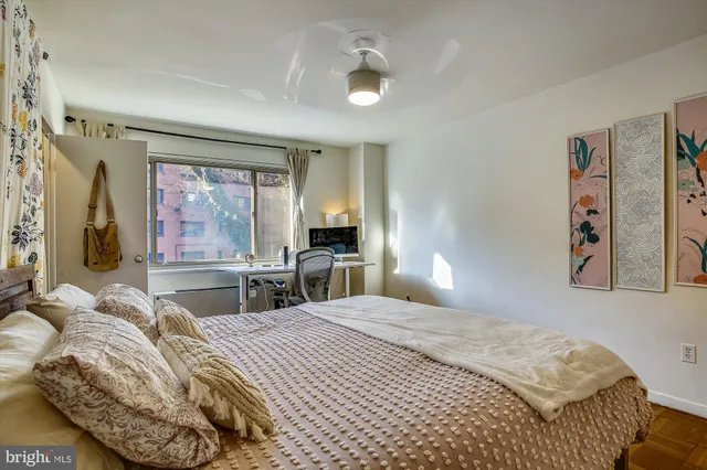 a bedroom with a bed and a large mirror on the dresser