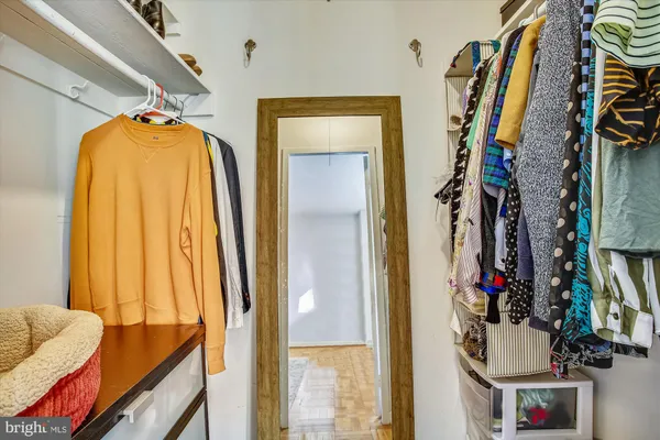 a view of walk in closet with clothes and shoes