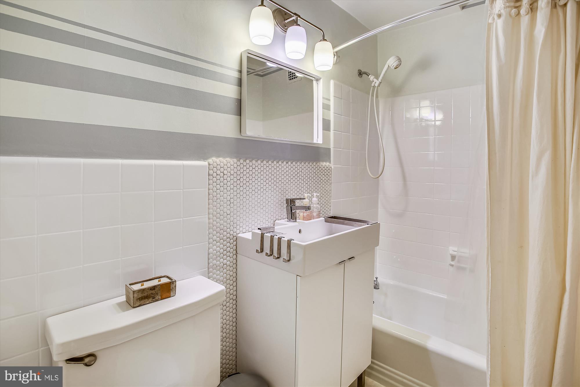 3900 Tunlaw Road Northwest, Unit 118 Washington, DC 20007 - Photo 21 of 58 a bathroom with a sink a toilet and shower
