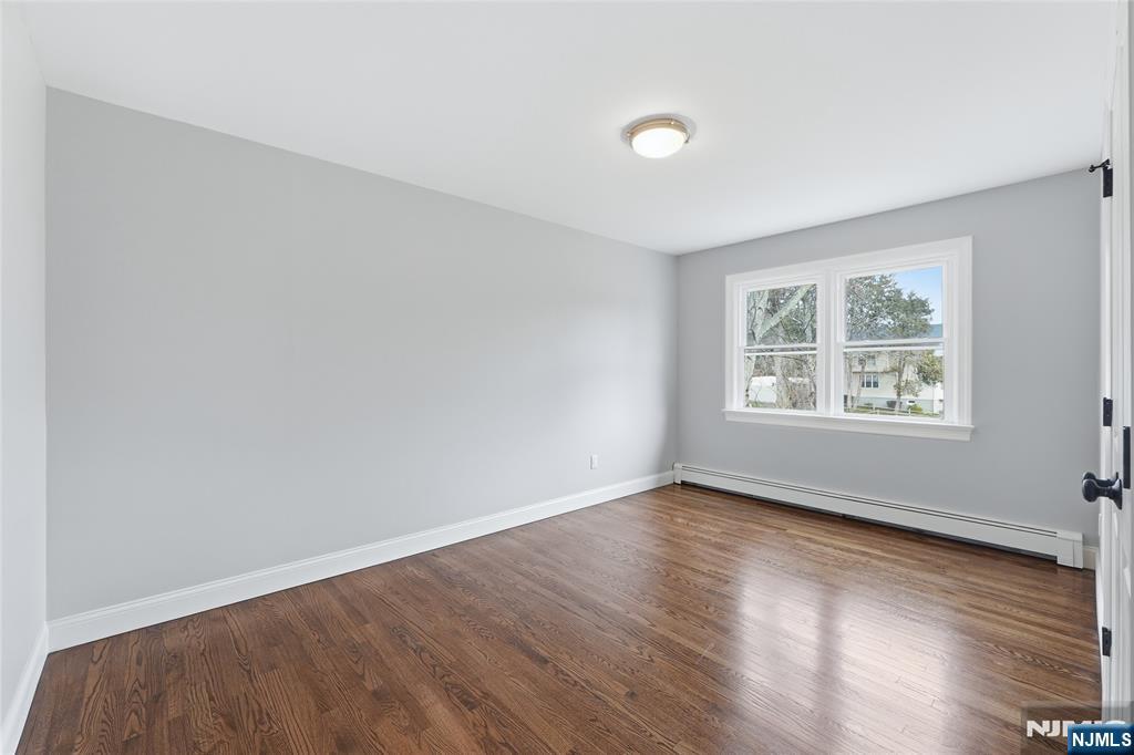 75 Colgate Avenue, Unit 2 Paramus, NJ 07652 - Photo 11 of 24 an empty room with wooden floor and windows