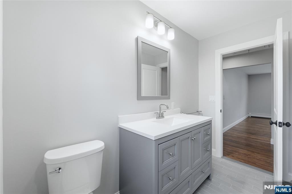 75 Colgate Avenue, Unit 2 Paramus, NJ 07652 - Photo 13 of 24 a bathroom with a toilet sink and mirror
