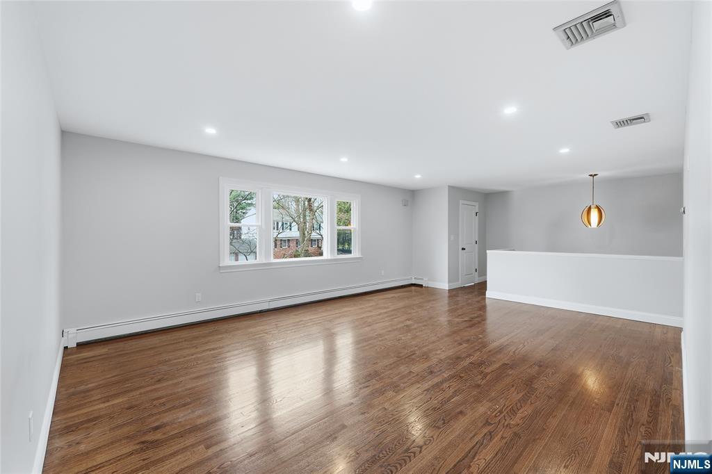 75 Colgate Avenue, Unit 2 Paramus, NJ 07652 - Photo 2 of 24 a view of an empty room with wooden floor and a window