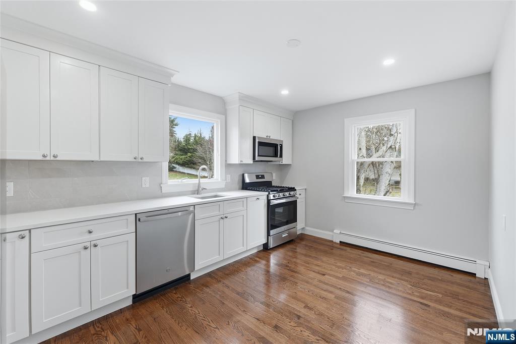 75 Colgate Avenue, Unit 2 Paramus, NJ 07652 - Photo 4 of 24 a kitchen with granite countertop white cabinets and black stainless steel appliances
