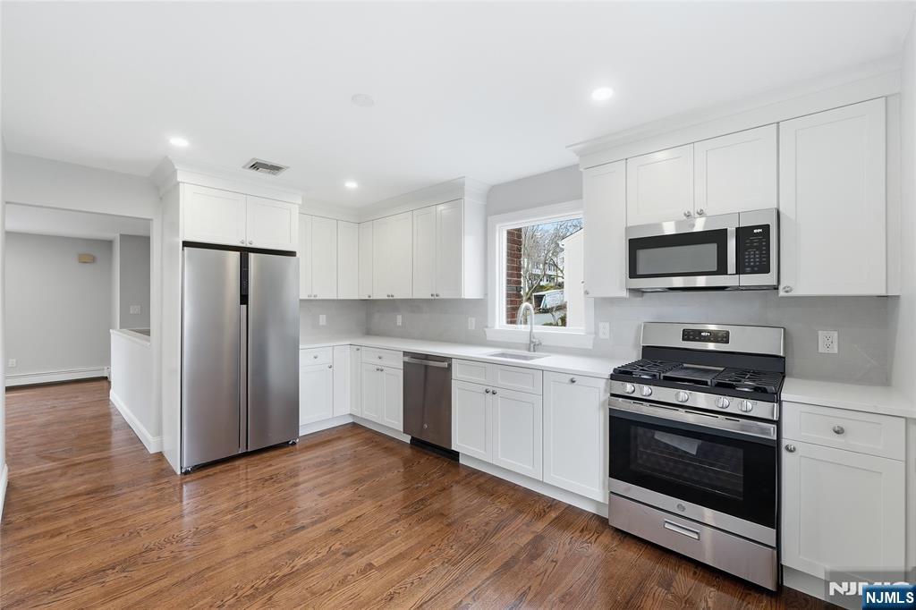 75 Colgate Avenue, Unit 2 Paramus, NJ 07652 - Photo 5 of 24 a kitchen with granite countertop a refrigerator stove and wooden floor