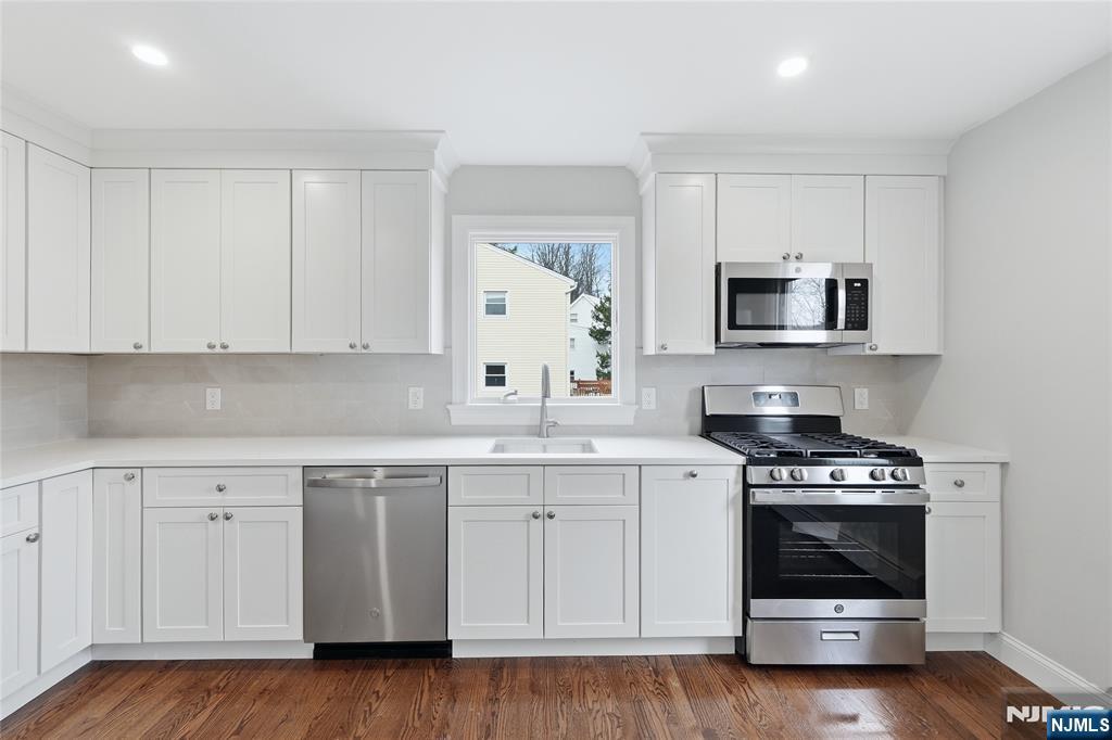 75 Colgate Avenue, Unit 2 Paramus, NJ 07652 - Photo 6 of 24 a kitchen with granite countertop a stove a sink and a microwave