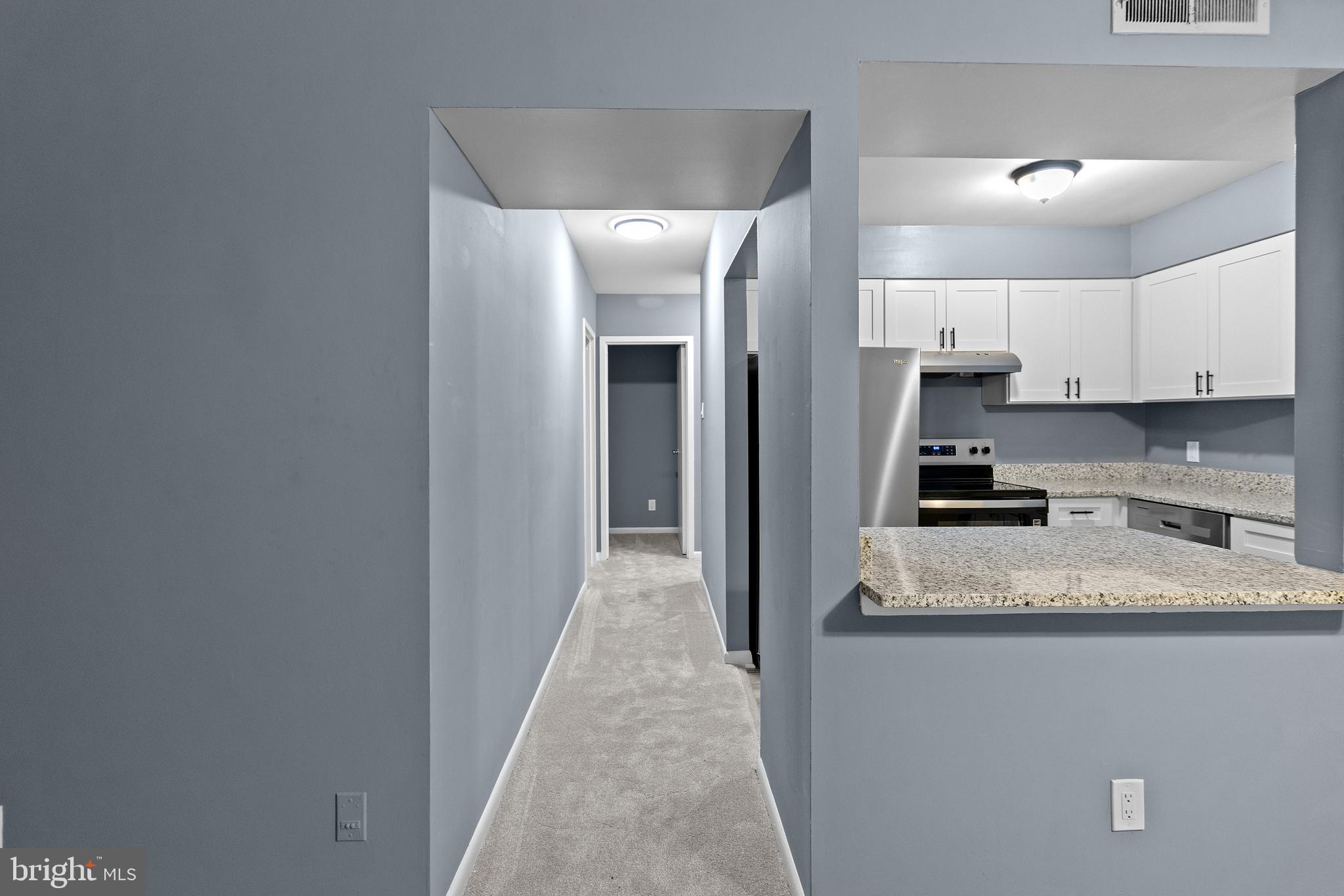 10121 Prince Place, Unit 30110B Upper Marlboro, MD 20774 - Photo 11 of 29 a view of a kitchen with granite countertop white cabinets and stainless steel appliances