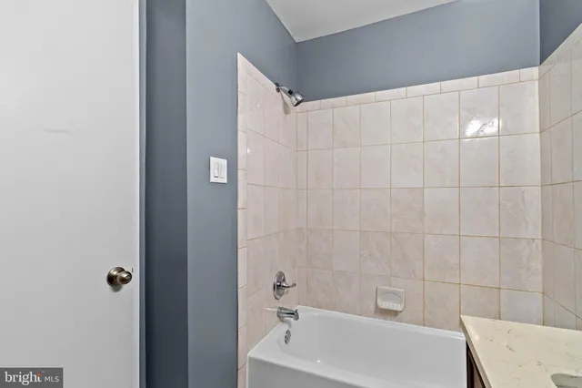 a bathroom with a white bath tub and a sink