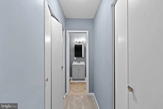 a view of a hallway with wooden floor and closet