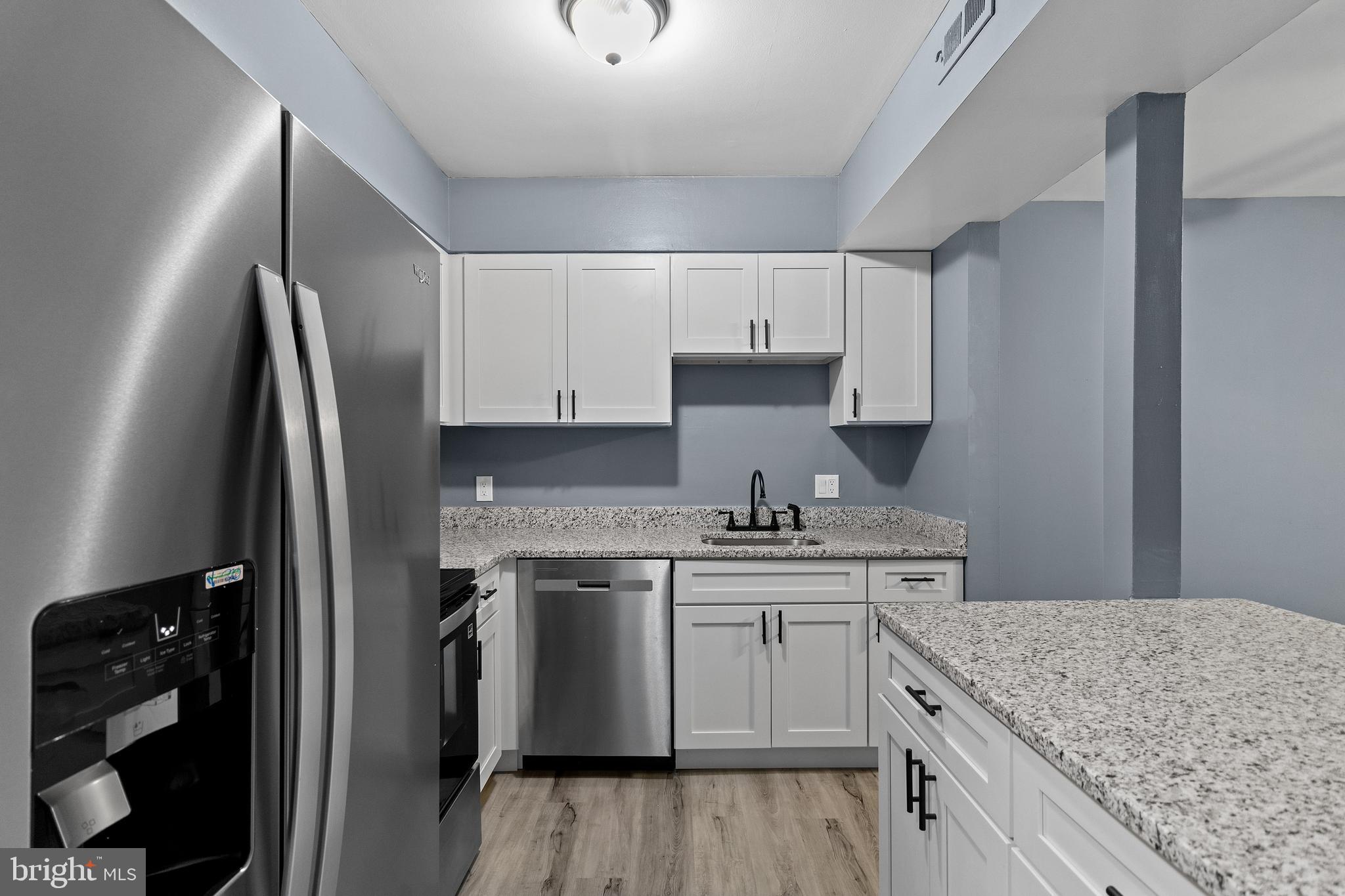 10121 Prince Place, Unit 30110B Upper Marlboro, MD 20774 - Photo 9 of 29 a kitchen with stainless steel appliances granite countertop a sink stove and refrigerator