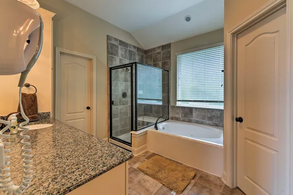 a spacious bathroom with a granite countertop tub sink and mirror