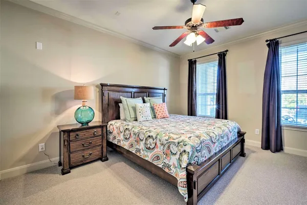 a bedroom with a bed a chandelier and a dresser