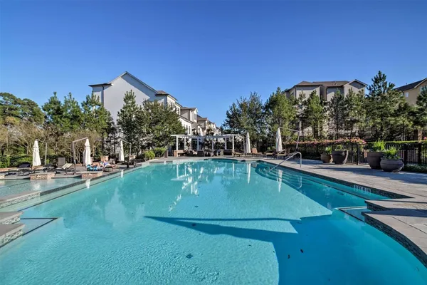 a view of a swimming pool with lawn chairs under an umbrella