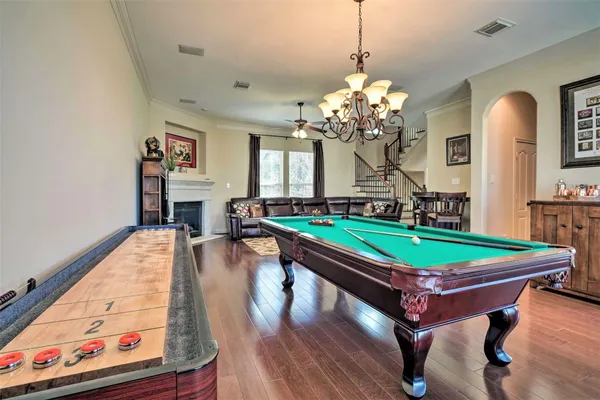 a room with pool table and wooden floor