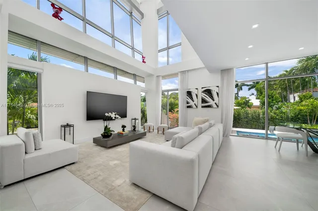 a bedroom with a large bed and a flat tv screen on dresser