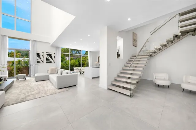 a view of a patio with chairs and table under an umbrella with potted plants