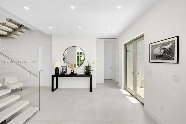 a living room with furniture a flat screen tv and floor to ceiling window