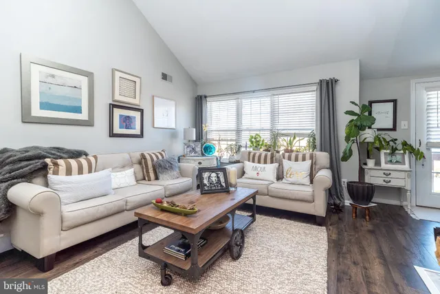 a living room with furniture a rug and a large window