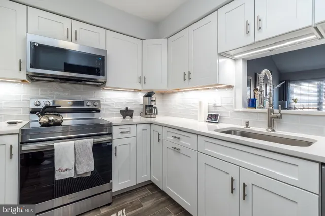 a kitchen with cabinets stainless steel appliances a sink and a counter space