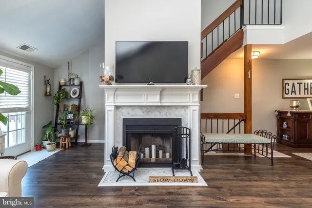 a living room with furniture a flat screen tv and a fireplace