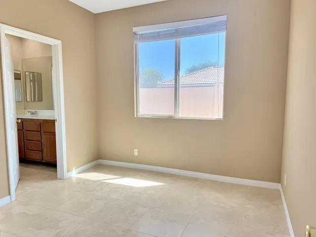 an empty room with a window and a dresser
